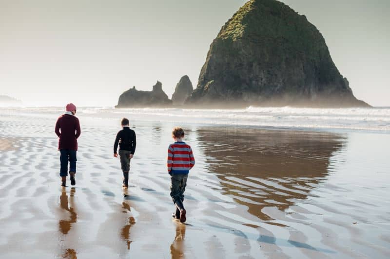 A family three walking on the beach.