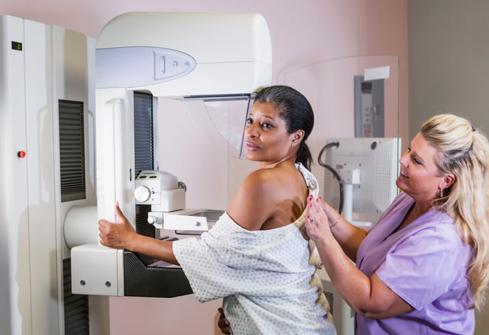 Mammography tech positions patient for mammogram