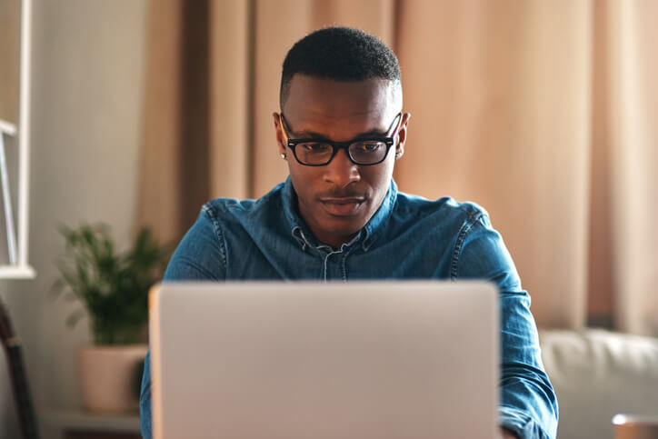 man in home looking at laptop man in home looking at laptop